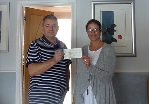 Mrs Mya Marsh receiving a cheque (and cash) for the sum of £645.